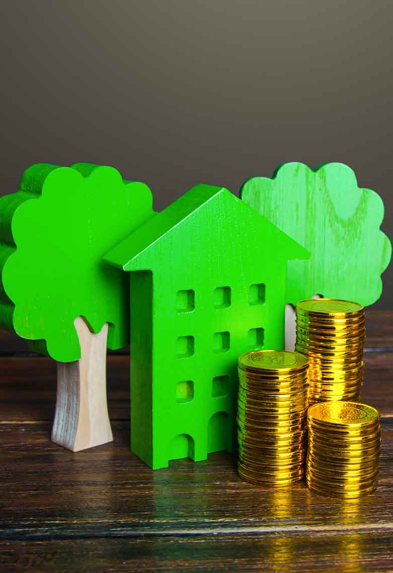 Stacks of coins and a green toy house