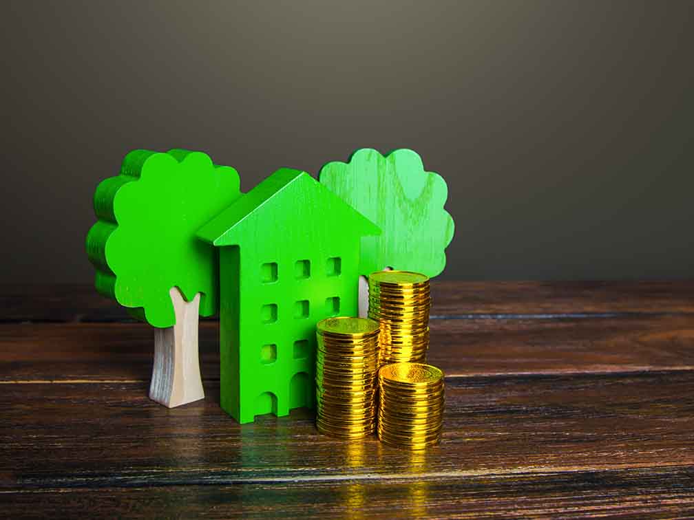 Stacks of coins and a green toy house