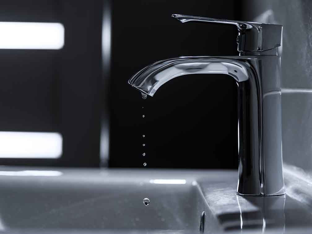 Modern silver tap dripping water