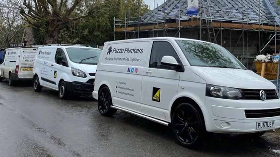 Puzzle Plumbers vans in front of new build house