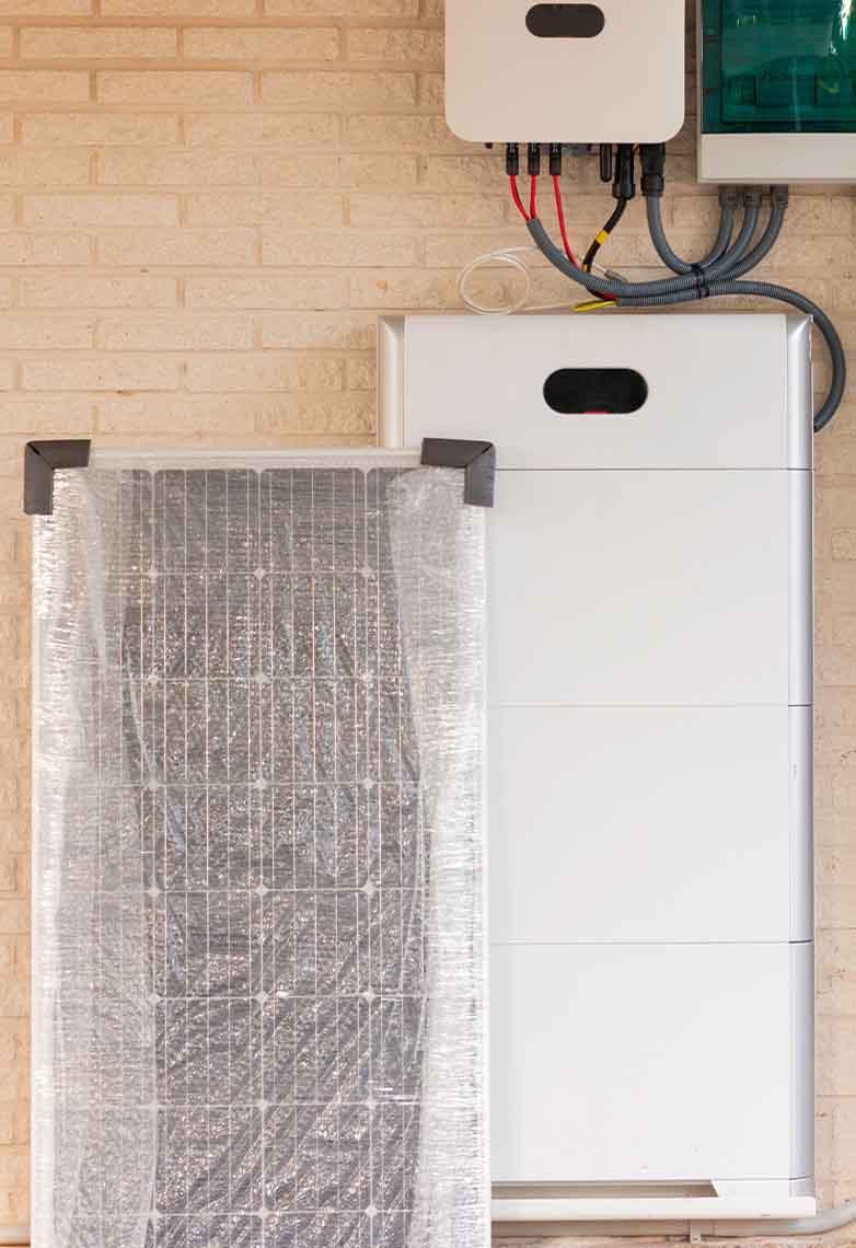 Solar energy battery on a brick wall with a new solar panel next to it